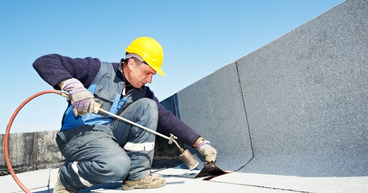 The Rich Co Inc. crew installing a white TPO membrane roof on a commercial building in Colorado Springs